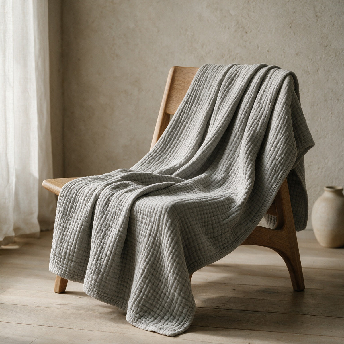 Linwood in Grey draped over a wooden lounge chair