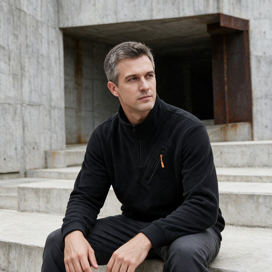 Man in a black knit jumper sitting on concrete steps